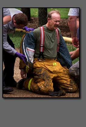 Firefighter is helped out of turnout coat.