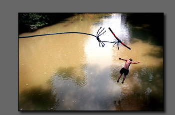 Boy jumps from rope swing into river